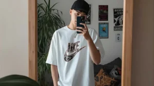 Person taking a mirror selfie in a bright bedroom, surrounded by plants and decor.